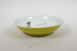 A Chinese yellow ground porcelain bowl with famille verte bird and flower decoration to the