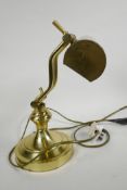 An adjustable brass 'bank' desk light on heavy circular base, 13" high