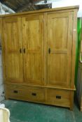 A contemporary oak triple door wardrobe, with two drawers, 63" x 23", 76" high
