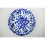 A Chinese blue and white porcelain charger with a lobed rim, decorated with a dragon chasing the