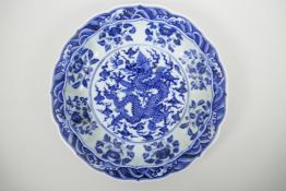 A Chinese blue and white porcelain charger with a lobed rim, decorated with a dragon chasing the