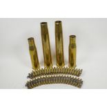 Two machine gun ammunition belts with empty shell cases, 25½" long, and four WWII brass shell cases,