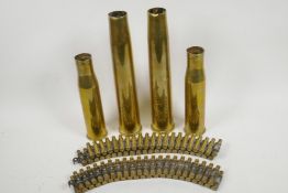 Two machine gun ammunition belts with empty shell cases, 25½" long, and four WWII brass shell cases,