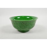 A Chinese green glazed porcelain rice bowl with raised dragon decoration, 6 character mark to