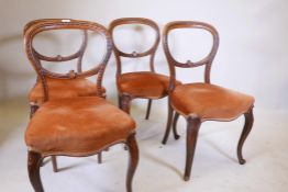 A set of four Victorian walnut balloon back chairs with carved decoration, 33" high