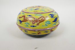 A Chinese polychrome porcelain box and cover with dragon decoration on a yellow ground, seal mark to