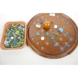 A large wooden solitaire board, A/F, together with a quantity of vintage marbles