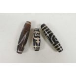 Three Tibetan stone dzi beads, largest 2½"