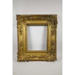 A C19th giltwood and composition picture frame, with shell and floral decoration, broad section