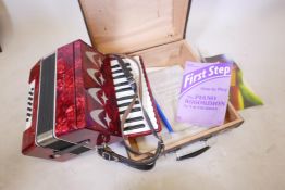 A piano accordion in case, with lesson books