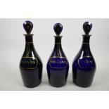 A Georgian set of three 'Bristol' blue glass spirit decanters, c.1790, with original lozenge