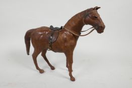 An antique leather model horse with glass eyes, 9" high