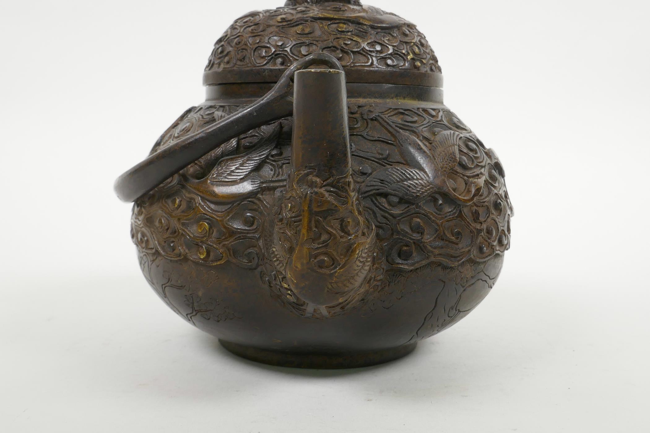 A Chinese bronze teapot with raised decoration of cranes in flight, four character mark to base, 5½" - Image 4 of 6