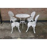 A painted metal garden table with three matching chairs and stool, 27" hgh x 31½" diameter
