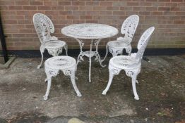 A painted metal garden table with three matching chairs and stool, 27" hgh x 31½" diameter