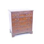 A mahogany bachelor's chest with brushing slide over four graduated drawers, fitted with brass