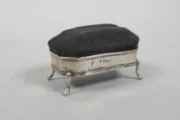 A hallmarked silver pin cushion on four cabriole supports, marked Chester 1910