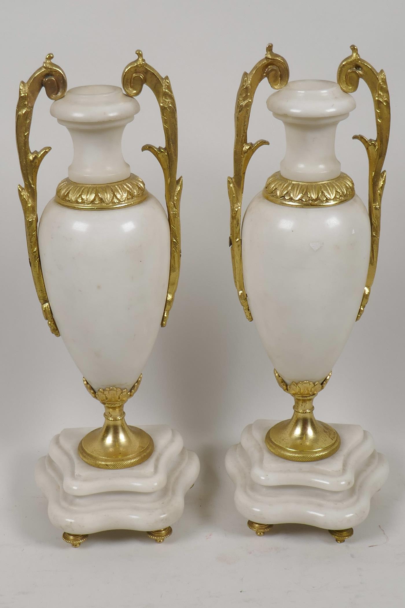A pair of ormolu mounted white marble side urns on shaped plinth bases, 10½" high