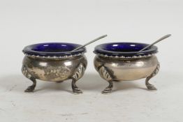 A pair of Edwardian sterling silver S.W. Smith & Co cruets, c.1906, with blue glass inserts (one