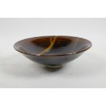 A studio pottery shallow bowl with a treacle glaze and swirl to interior, 8" diameter