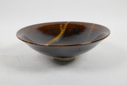 A studio pottery shallow bowl with a treacle glaze and swirl to interior, 8" diameter