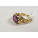 An antique yellow metal ring with pierced shoulders, set with a ruby, 4.8g