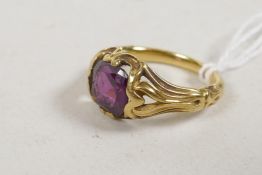 An antique yellow metal ring with pierced shoulders, set with a ruby, 4.8g