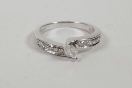 A 9ct white gold ring set with a central marcasite cut diamond and diamond channel shoulders,