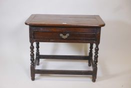 A C18th oak single drawer side table with adaptions, raised on turned supports united by stretchers,