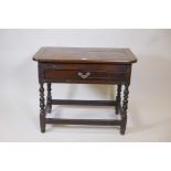 A C18th oak single drawer side table with adaptions, raised on turned supports united by stretchers,