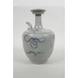 An oriental blue and white pottery archaic pourer with scrolling decoration, 9" high