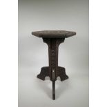 A Burmese carved hardwood hexagonal top wine table on tripod supports, 15" x 13" x 20½" high