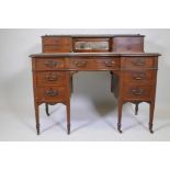 A Victorian inlaid walnut shaped front seven drawer kneehole desk with upper section and brass