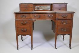 A Victorian inlaid walnut shaped front seven drawer kneehole desk with upper section and brass