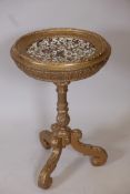 A carved giltwood centre table on column support and tripod feet, the top set with a Szolnay