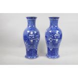 A pair of Chinese blue and white vases, decorated with precious objects on a scrolling blue