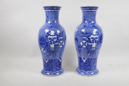 A pair of Chinese blue and white vases, decorated with precious objects on a scrolling blue