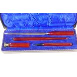 A metal cased desk writing set of paper knife, pen, pencil and seal with composition handles