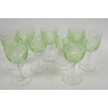 A suite of nine uranium wine glasses star cut decorated on clear stems, 5" high