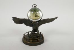 A brass ball desk clock mounted on a stand in the form of an eagle, 5" high x 7" wide