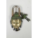 A Tibetan brass padlock in the form of the Buddha's head, the keys decorated with vajras, 6"