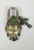 A Tibetan brass padlock in the form of the Buddha's head, the keys decorated with vajras, 6"