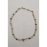 An antique yellow metal necklace with enamelled links and set with precious and semi precious