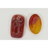 A pair of carnelian engraved intaglios, one carved with a head profile, the other with a religious