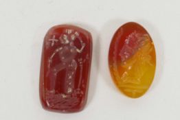 A pair of carnelian engraved intaglios, one carved with a head profile, the other with a religious