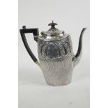 A hallmarked silver coffee pot with whorled chased and engraved decoration with vacant cartouches to
