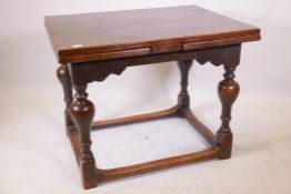 A late C19th/early C20th oak drawleaf table, raised on baluster supports united by stretchers, 30" x