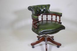 A tilt and swivel desk chair with button back leather upholstery