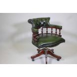 A tilt and swivel desk chair with button back leather upholstery