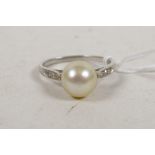 A white metal ring, with diamond set shoulders and large pearl, 3.3g